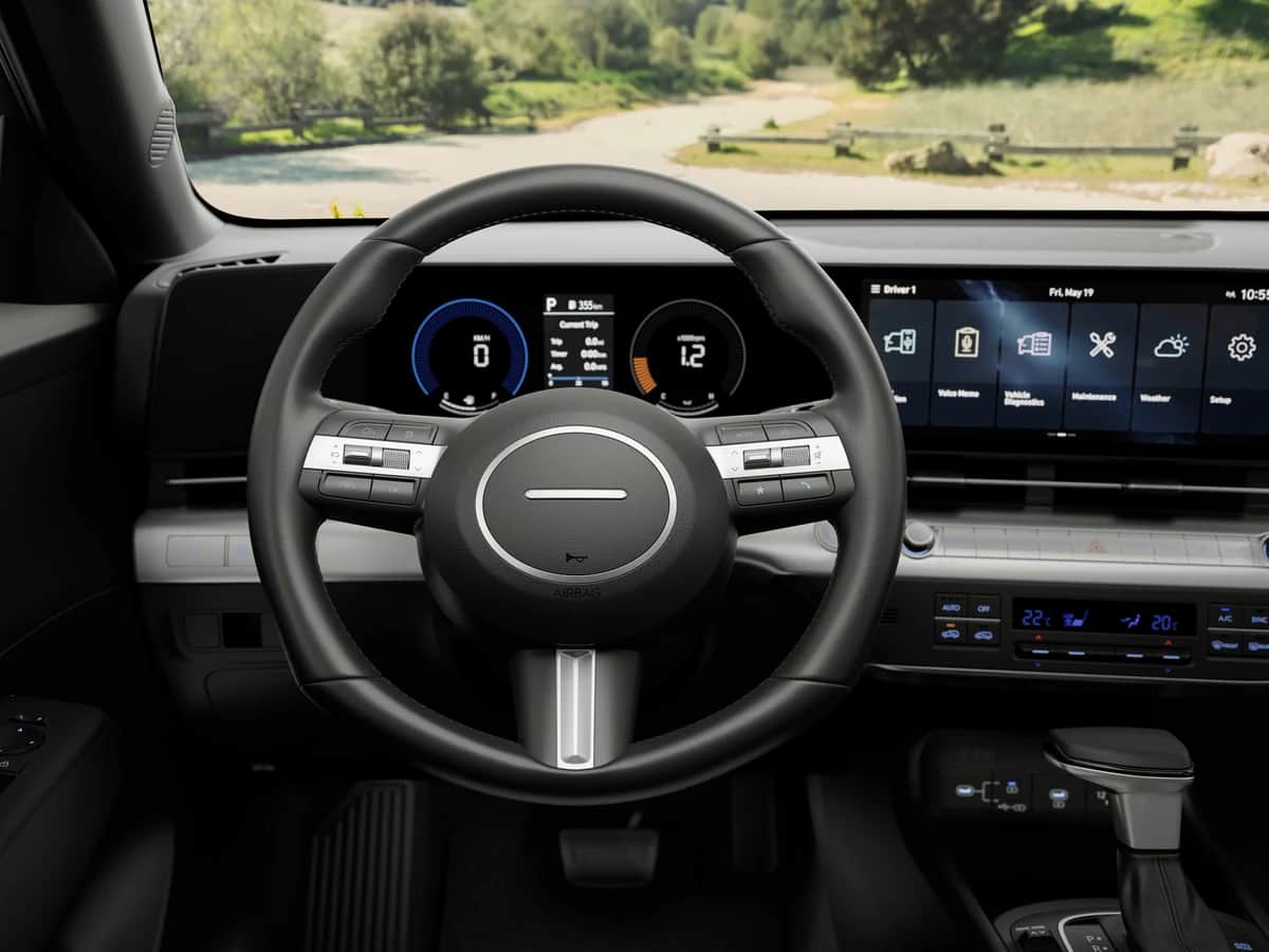 2026 Hyundai Kona cockpit: leather-wrapped steering wheel, digital instrument cluster and centre screen, in daylight