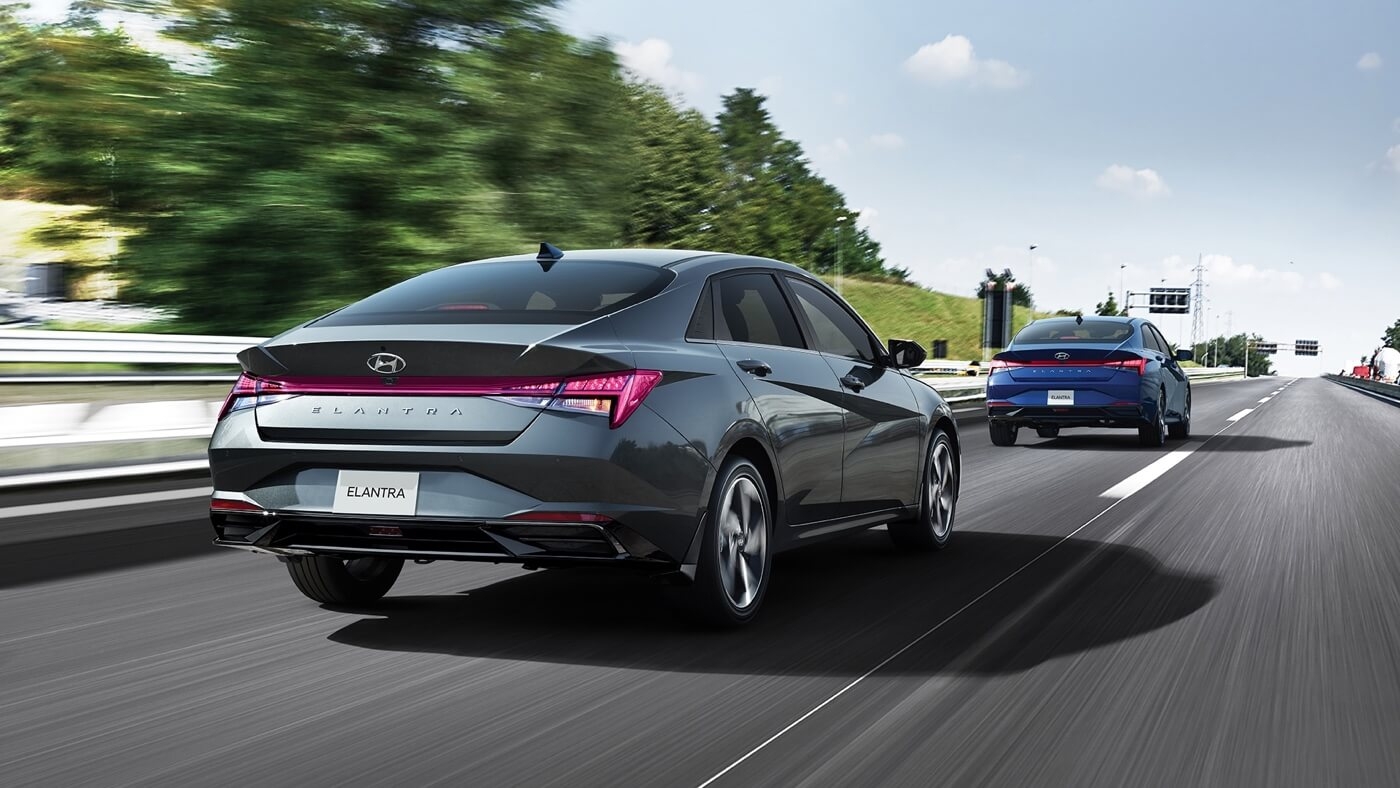 Vue 3/4 arrière de la Hyundai Elantra 2024 roulant en toute sécurité sur une route.