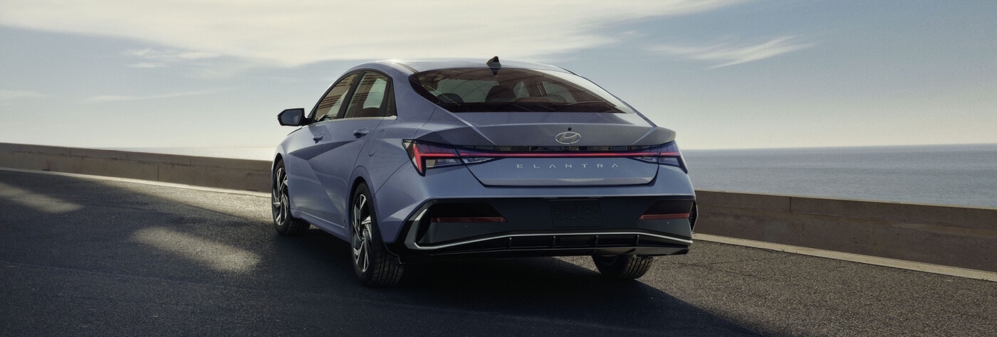 Vue 3/4 arrière de la Hyundai Elantra 2025 sur une route.